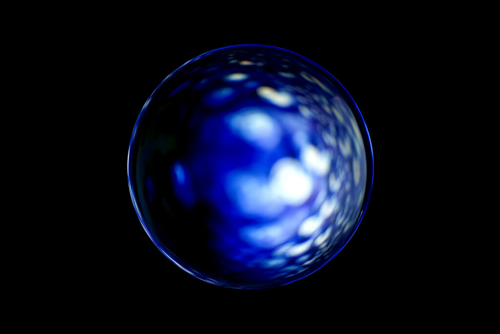Abstracte foto van een gloeiende blauwe glasbol met lichte reflecties op zwarte achtergrond.